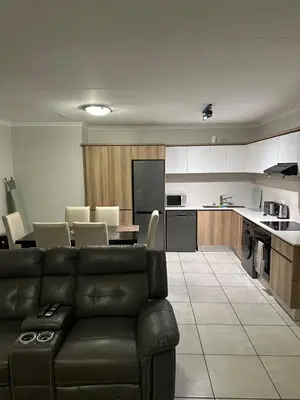 a living room with a couch and a kitchen at The Blyde Pretoria in Pretoria