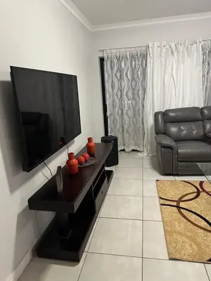 a living room with a couch and a flat screen tv at The Blyde Pretoria in Pretoria