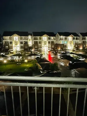 a parking lot with cars and buildings at night at The Blyde Pretoria in Pretoria