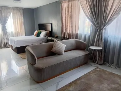 a living room with a couch and a bed at Kings Lifestyle Apartments, City Retreat in Pretoria