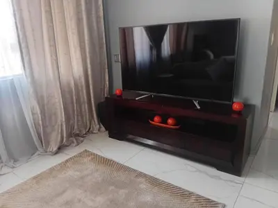 a flat screen tv sitting on a dresser in a living room at Kings Lifestyle Apartments, City Retreat in Pretoria