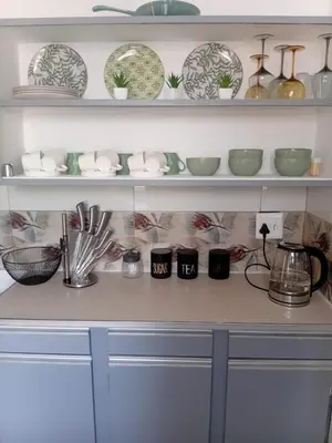 a shelf with plates and bowls on it at Kings Lifestyle Apartments, City Retreat in Pretoria