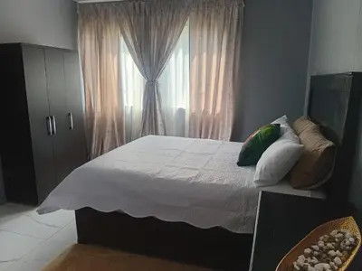 a bedroom with a large bed with a window at Kings Lifestyle Apartments, City Retreat in Pretoria