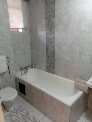 a bathroom with a bath tub and a toilet at Kings Lifestyle Apartments, City Retreat in Pretoria