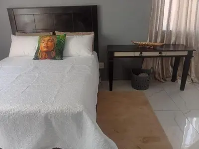 a bedroom with a bed and a desk with a pillow at Kings Lifestyle Apartments, City Retreat in Pretoria