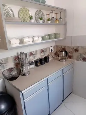 a kitchen counter with plates and bowls on shelves at Kings Lifestyle Apartments, City Retreat in Pretoria