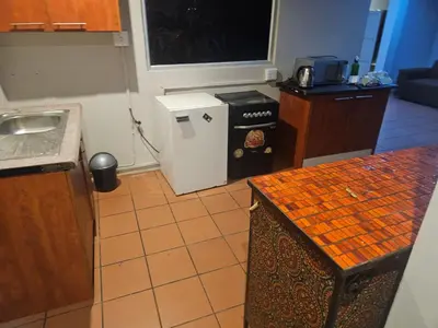 a kitchen with a sink and a small refrigerator at Jakaranda house in Pretoria