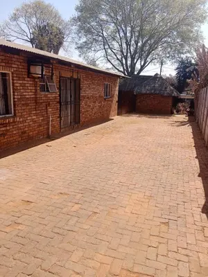 an empty brick driveway next to a brick building at Jakaranda house in Pretoria