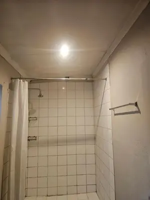 a bathroom with a shower with a light on the ceiling at Jakaranda house in Pretoria