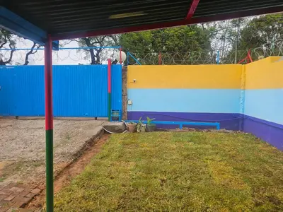 a playground with a blue and yellow wall at Jakaranda house in Pretoria