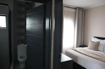 a bedroom with a bed and a toilet in a room at Luxury Modern Apartment Prime Midrand Location in Midrand