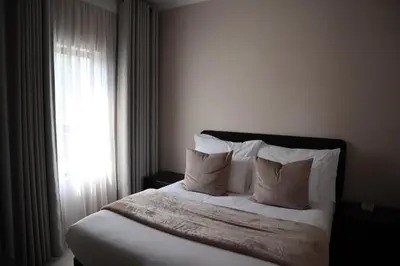 a bedroom with a bed with pillows and a window at Luxury Modern Apartment Prime Midrand Location in Midrand