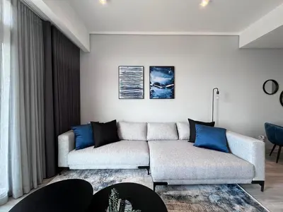 a living room with a couch and blue pillows at The Trilogy Collection Luxury One Bedroom in Pretoria
