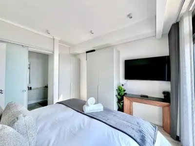 a bedroom with a bed and a flat screen tv at The Trilogy Collection Luxury One Bedroom in Pretoria