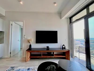 a living room with a flat screen tv on a wall at The Trilogy Collection Luxury One Bedroom in Pretoria