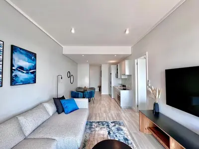 a living room with a couch and a flat screen tv at The Trilogy Collection Luxury One Bedroom in Pretoria