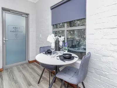a dining room with a table and chairs and a window at Links & Lavender in Centurion