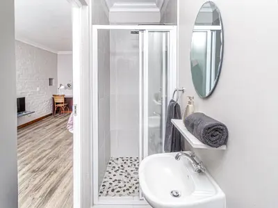 a bathroom with a shower and a sink and a mirror at Links & Lavender in Centurion