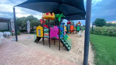 a childrens playground with an umbrella in a park at Links & Lavender in Centurion