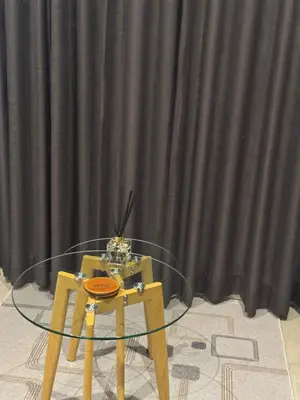 a glass table and chair in front of a black curtain at 1128 Executive Studio, The Capital Triology in Pretoria