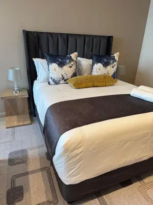 a large bed with a black headboard in a room at 1128 Executive Studio, The Capital Triology in Pretoria