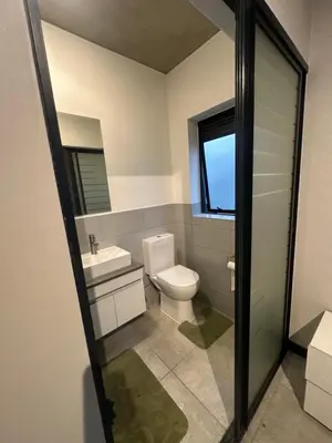 a bathroom with a toilet and a sink at The luxury IN waterfall Midrand in Midrand
