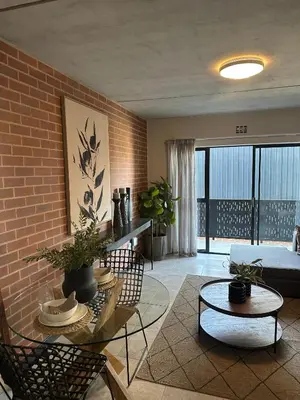 a living room with a couch and a brick wall at The luxury IN waterfall Midrand in Midrand