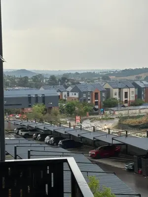 a parking lot with cars parked in front of buildings at The luxury IN waterfall Midrand in Midrand
