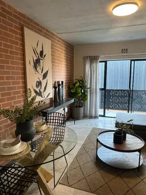 a living room with plants and a brick wall at The luxury IN waterfall Midrand in Midrand