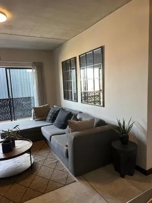 a living room with a couch and a table at The luxury IN waterfall Midrand in Midrand