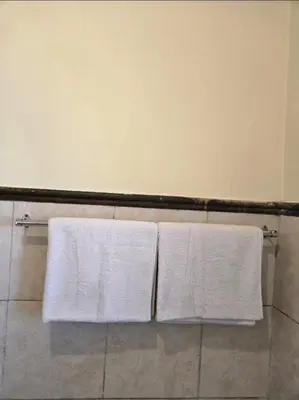 two white towels hanging on a towel rack in a bathroom at THE Y's HOME in Centurion