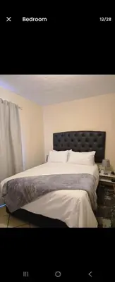 a bedroom with a large bed with white sheets at THE Y's HOME in Centurion