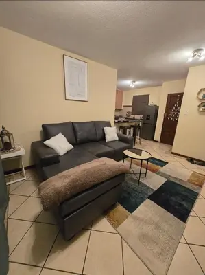 a living room with a couch and a table at THE Y's HOME in Centurion