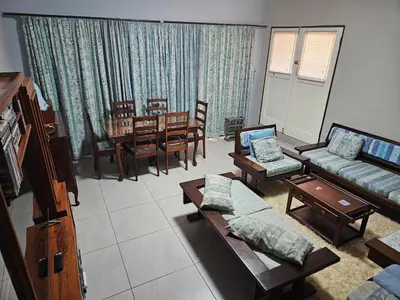 a living room with a couch and a dining room at Luxury Meets Convenience Near City & Travel Links in Pretoria