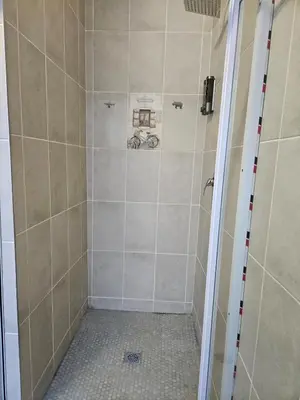 a bathroom with a shower with tiled walls at Luxury Meets Convenience Near City & Travel Links in Pretoria