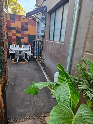 a patio with a table and a bench in front of a building at Luxury Meets Convenience Near City & Travel Links in Pretoria
