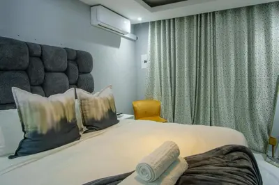 a hotel room with a large bed and a chair at Unit 5 and 6 Homely Escapes in Phalaborwa