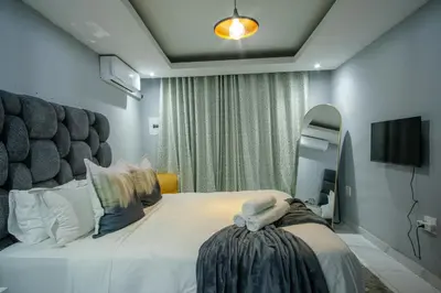 a bedroom with a large bed and a mirror at Unit 5 and 6 Homely Escapes in Phalaborwa