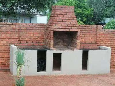 a brick wall with a brick oven in a yard at F'leur Guesthouse in Mokopane