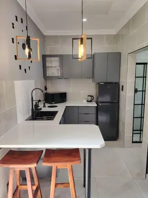 a kitchen with a white table and two chairs at F'leur Guesthouse in Mokopane