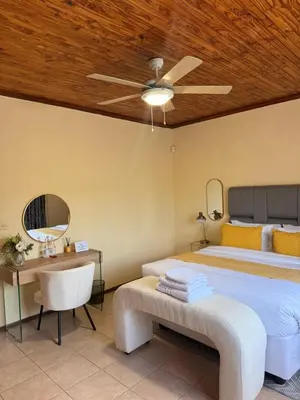 a bedroom with a bed and a ceiling fan at Soulfenda guest house in Graskop