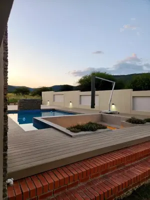 a backyard with a swimming pool and a wooden deck at Euphoria 447 in Naboomspruit