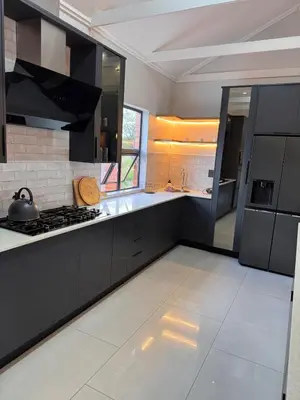 a kitchen with black cabinets and a stove top oven at Euphoria 447 in Naboomspruit
