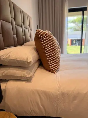 a bed with a pillow on it with a window at Euphoria 447 in Naboomspruit
