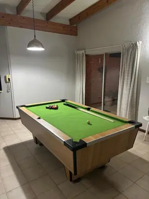 a pool table in a living room with afits at Catrachos Place in Pretoria