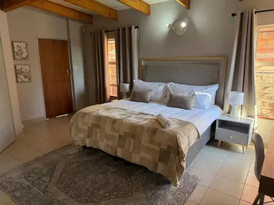 a bedroom with a large bed in a room at Catrachos Place in Pretoria