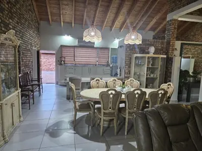 a kitchen and dining room with a table and chairs at Chandané Guesthouse in Thabazimbi