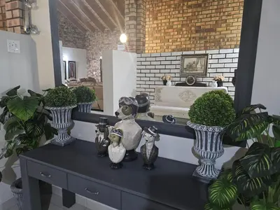 a table with vases on top of it with plants at Chandané Guesthouse in Thabazimbi