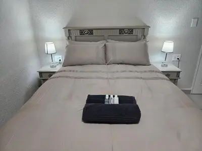 a bed with two night stands and two lamps on it at Chandané Guesthouse in Thabazimbi