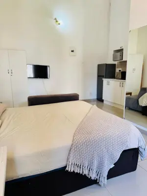 a bedroom with a large bed in a room at Airport Guest House in Kempton Park